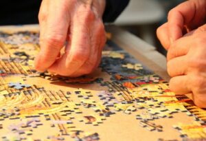 hands working a jigsaw puzzle